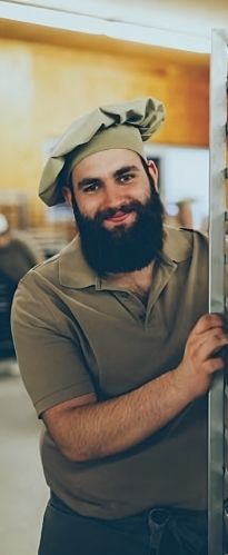 Bäcker mit einem Blech voller Backwaren